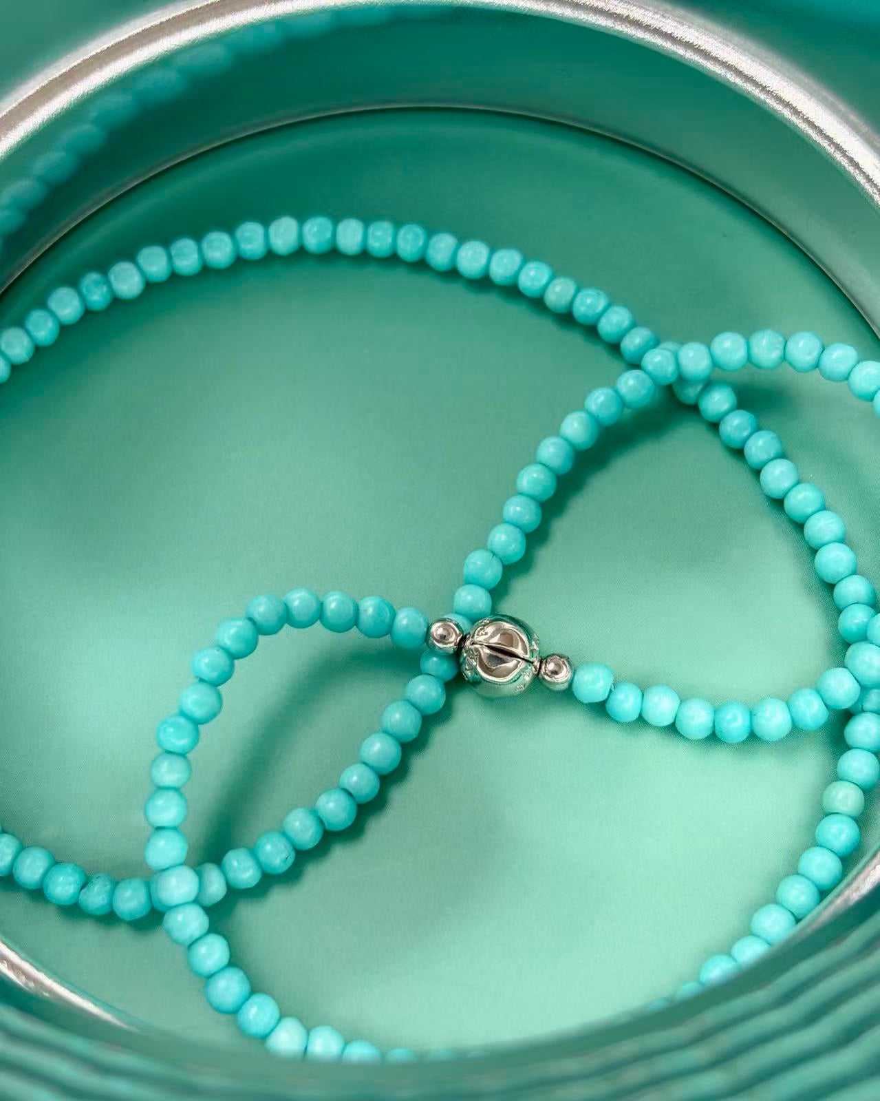 Turquoise beaded necklace on a matching turquoise plate