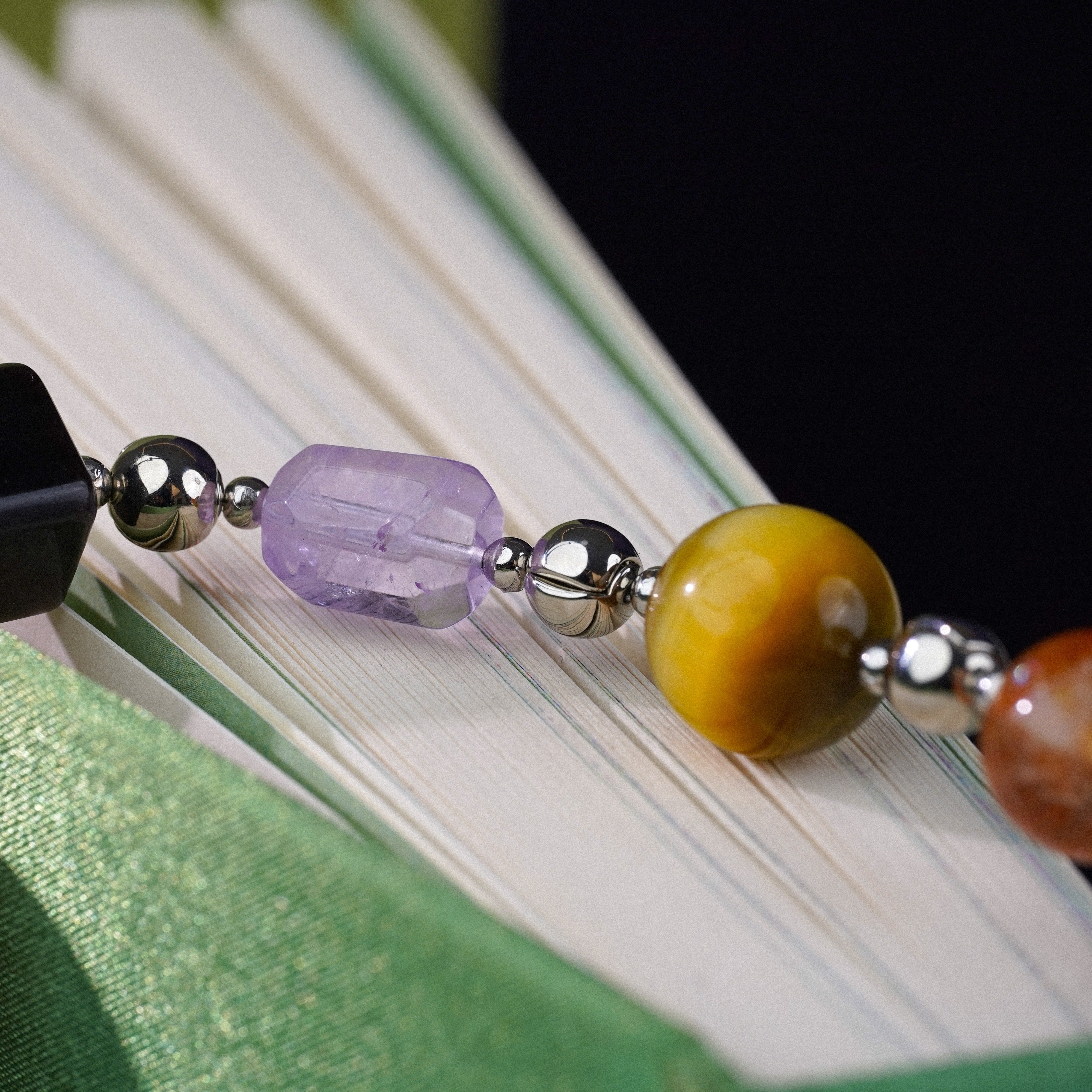 Colorful beaded bookmark on a book with a green cover
